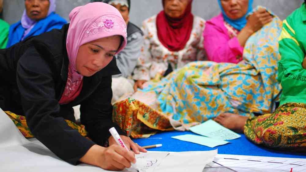 woman involved in community meeting to discuss village reconstruction